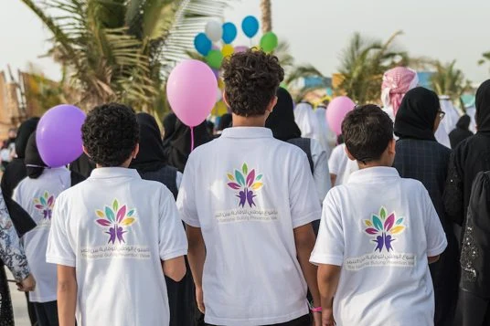 Three boys from behind, the mark on the backs of their T-shirts, balloons ahead