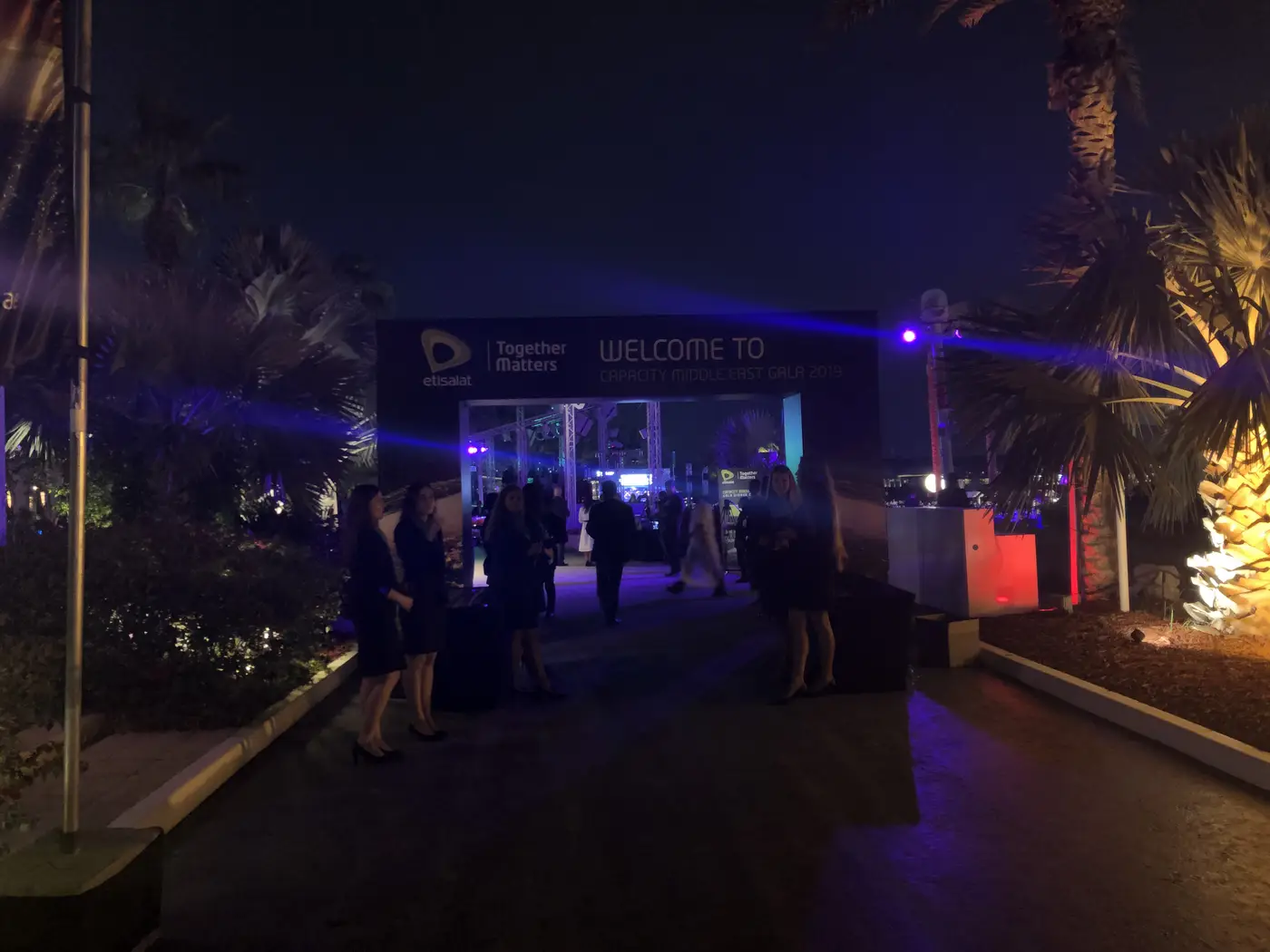 Photograph at night: the arrival arch, Welcome to Capacity Middle East Gala 2019, guests walking in under purple light